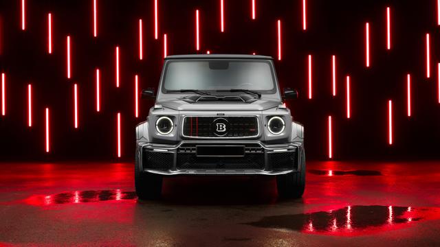 Front view of a metallic silver luxury SUV parked in a dark room illuminated by vertical red neon light bars reflecting off the ground.