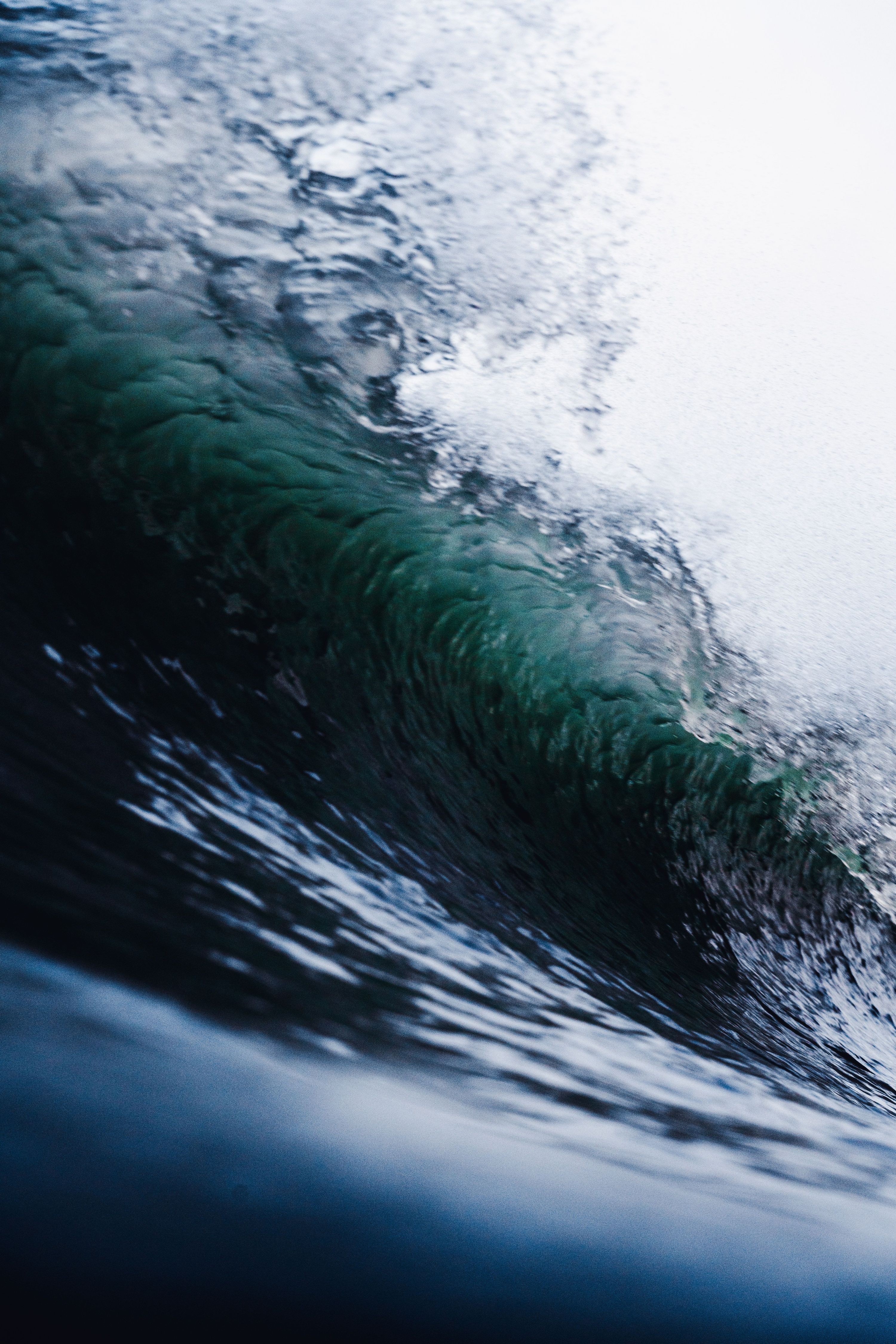 From below of shiny powerful wave of stormy turquoise ocean with transparent wat